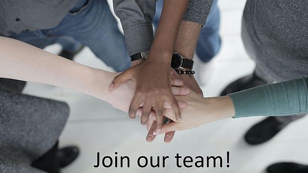 Hände von Menschen verschiedener Hautfarben liegen aufeinander. Es sind keine Köpfe zu sehen, sondern nur Hände, Füße, Beine, dazu der Schriftzug "Join our team!"